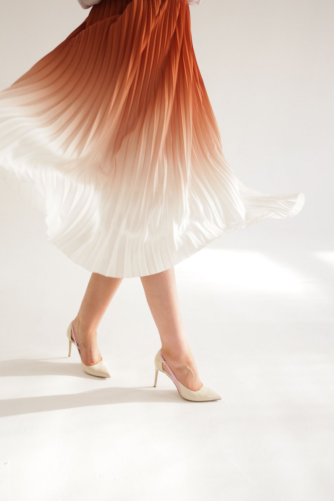 Pleated skirt in motion, showing the garment’s soft folds