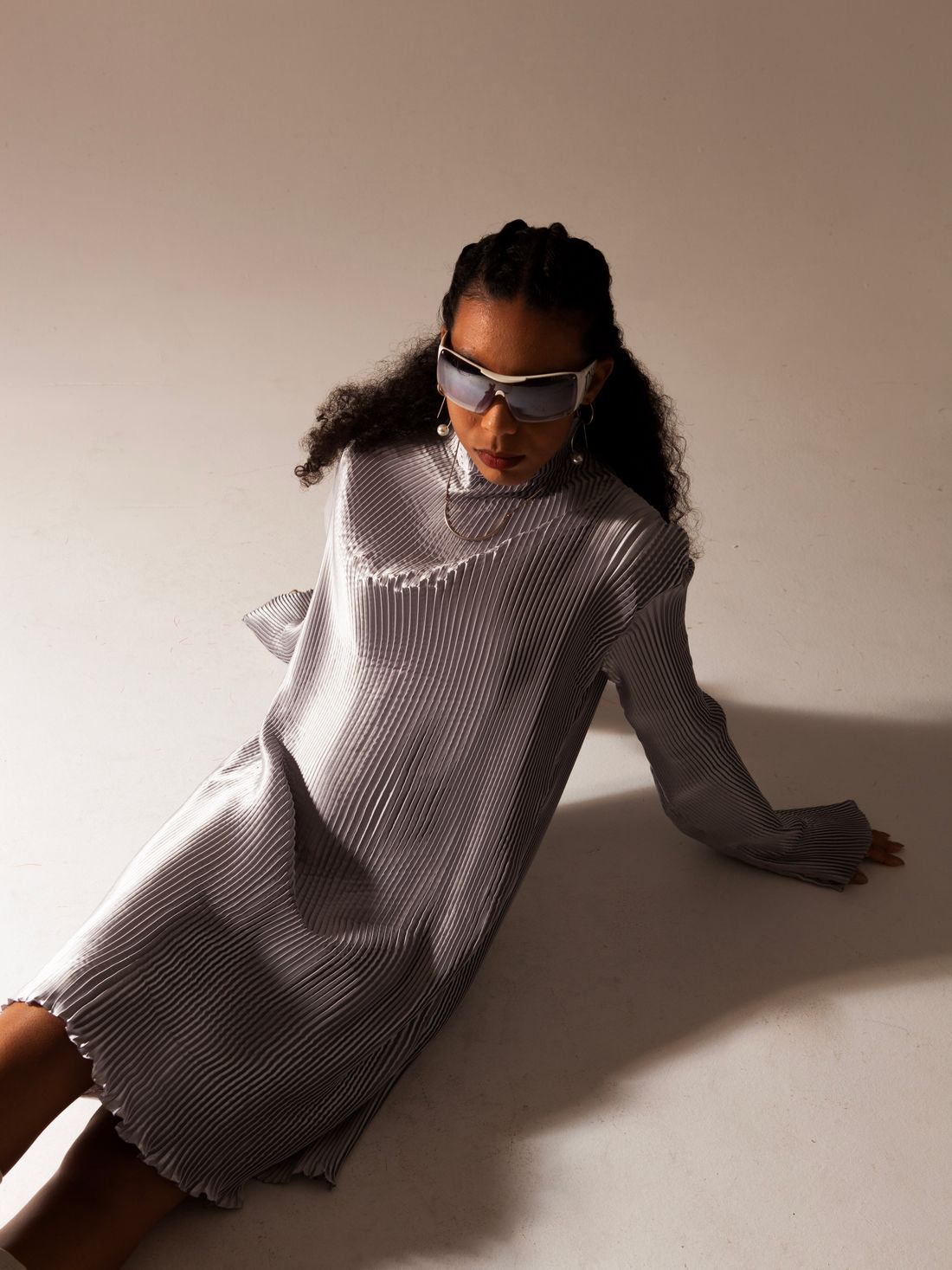 Model wearing a pleated dress in a studio